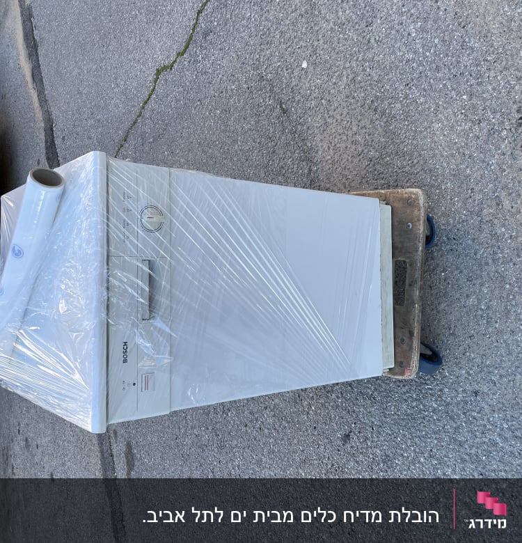 מכונת כביסה עטופה בניילון על עגלת הובלה
